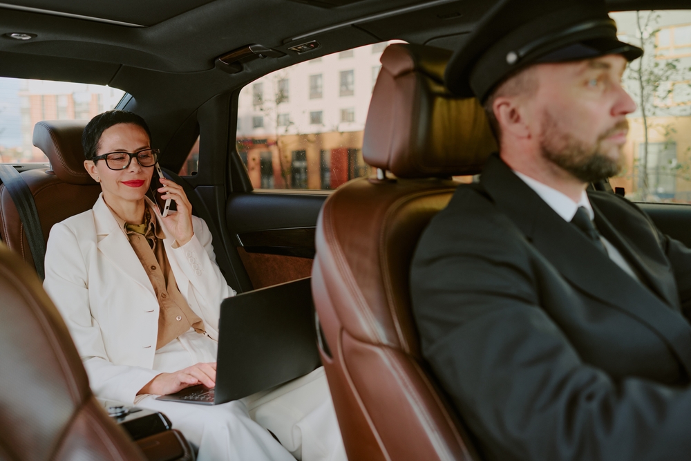 Professional chauffeur driving a passenger through a busy city